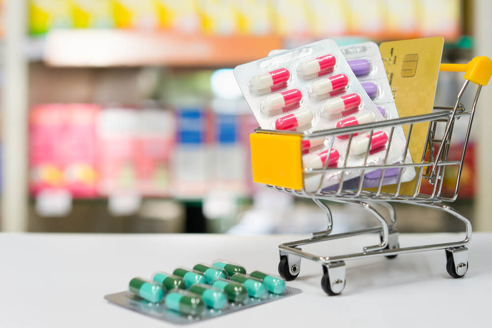 mini shopping cart with blister packs of colorful pills